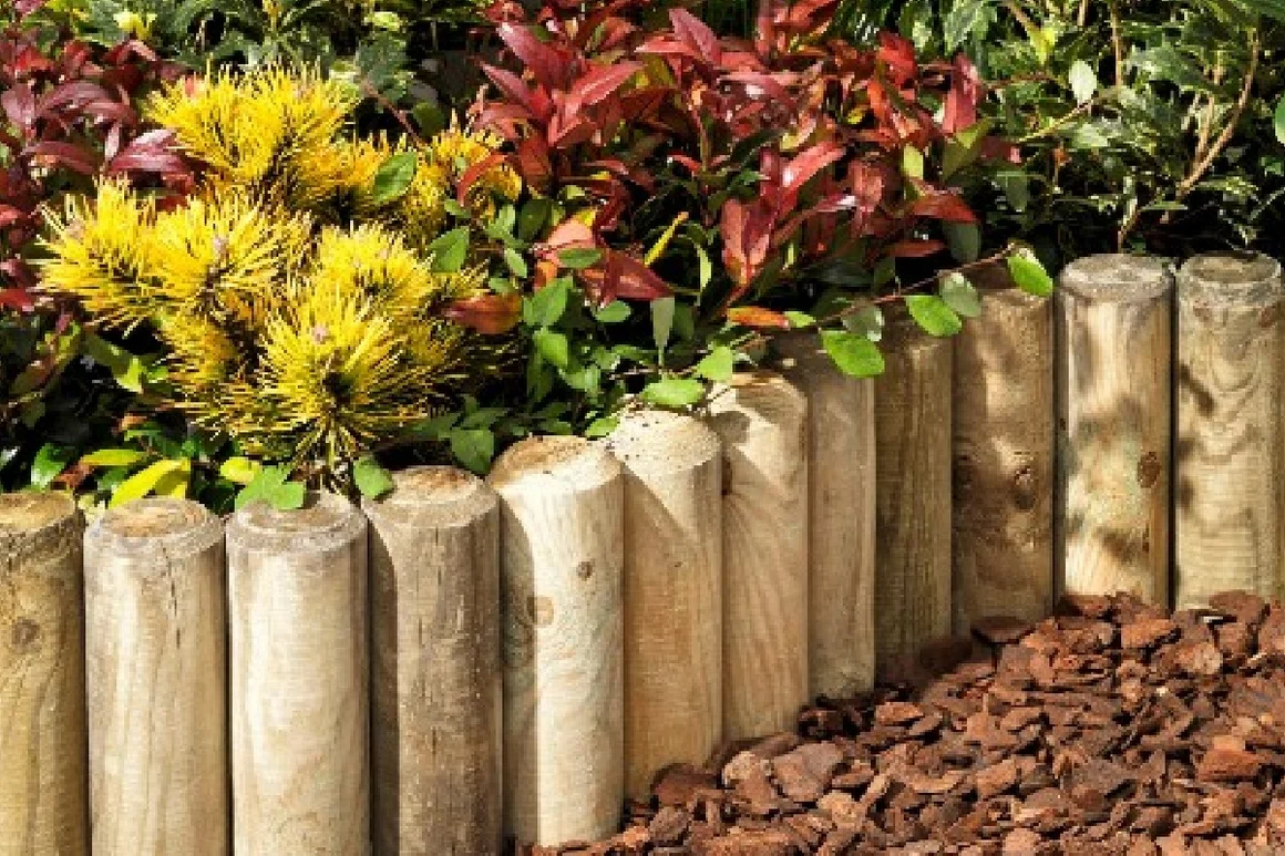 Holzpfähle als Gartenbegrenzung